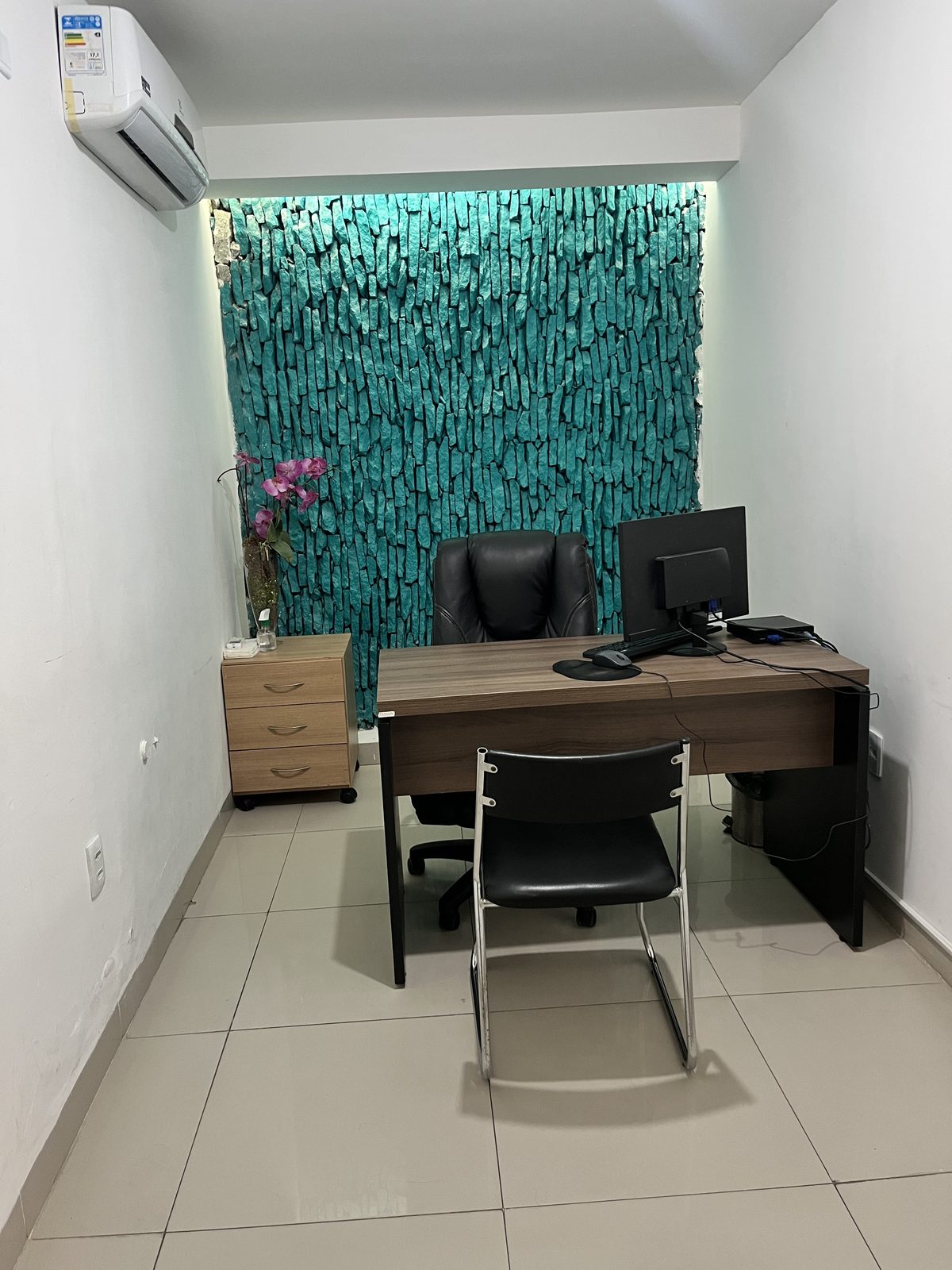 Mesa de atendimento com parede verde decorada ao fundo