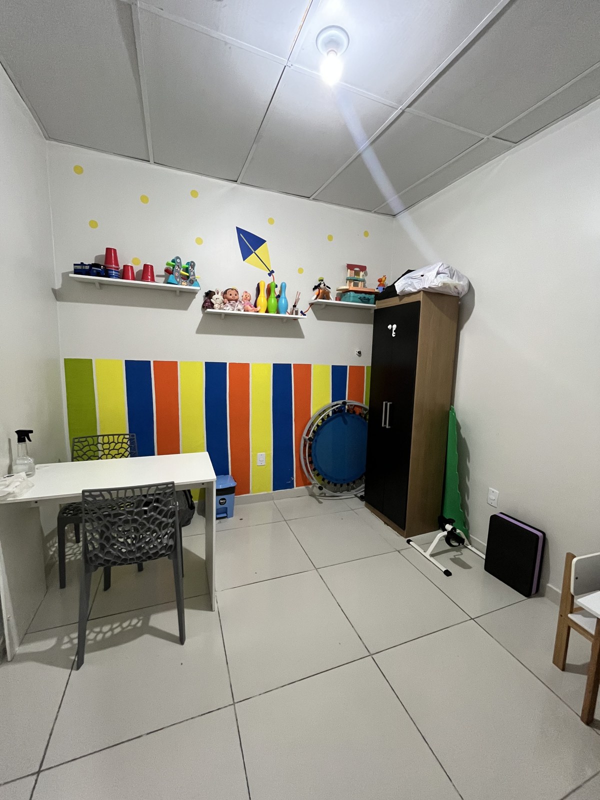 Sala infantil com brinquedos, cama elástica e equipamentos de atividade