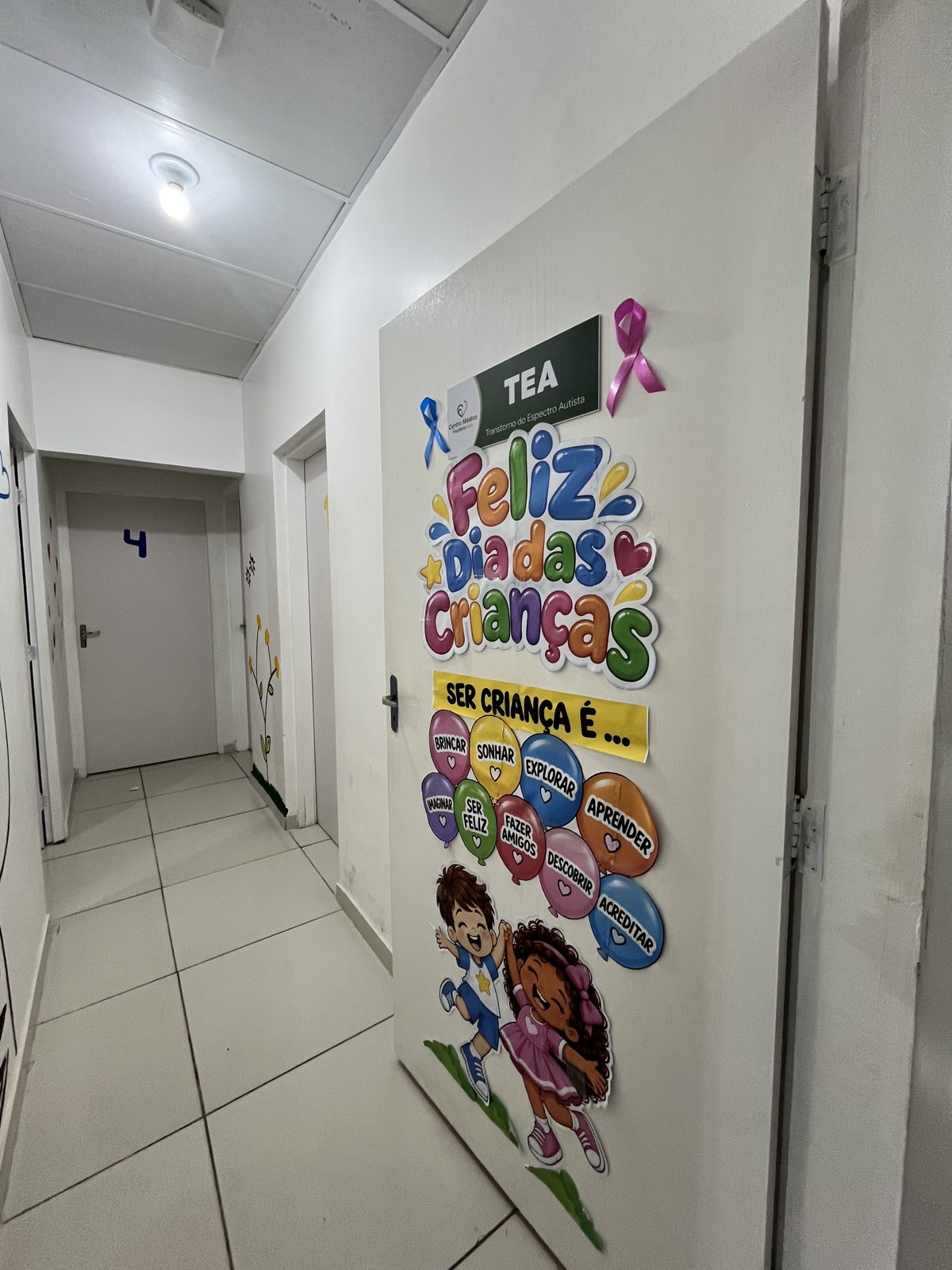 Porta da sala de atendimento infantil com placa TEA — Transtorno do Espectro Autista